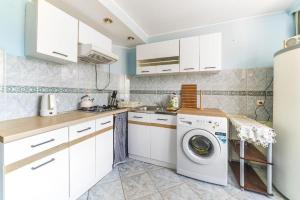 a white kitchen with a washing machine in it at SŁONECZNIK in Ostrowo