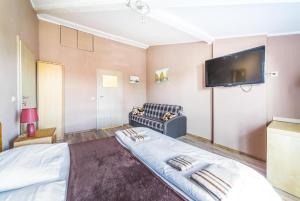 a bedroom with a bed and a flat screen tv at SŁONECZNIK in Ostrowo