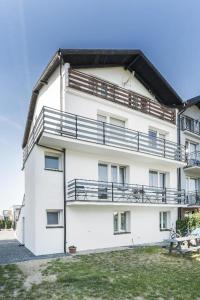 a white building with balconies on the side of it at SŁONECZNIK in Ostrowo