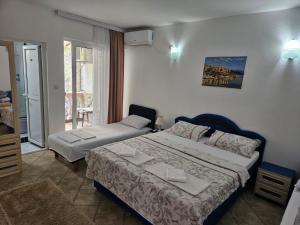a hotel room with two beds and a balcony at Apartments FLORA and boat cruising in Virpazar