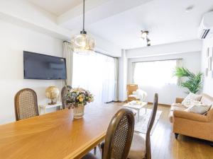 a dining room with a wooden table and a couch at AirStay Horikiri 301 - Vacation STAY 45405v in Tokyo