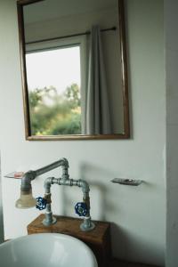 een wastafel in de badkamer met een spiegel en een kraan bij JH Hotel Tlatlauqui in Tlatlauquitepec