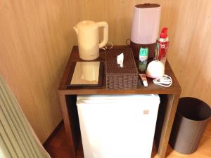ein kleiner Tisch mit einer Kaffeemaschine darauf in der Unterkunft Minshuku nicoichi in Yakushima