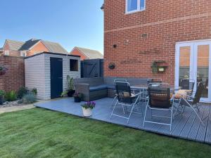 a deck with chairs and a table in a yard at Lovely 3 bed house near Anfield Stadium with private parking and garden Guests must be 25 years or over to make a booking in Liverpool