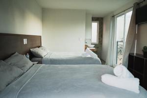 een hotelkamer met 2 bedden en handdoeken erop bij JH Hotel Tlatlauqui in Tlatlauquitepec