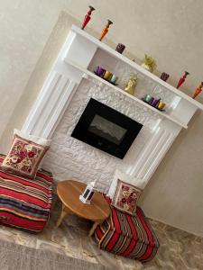 een woonkamer met een open haard met een tafel en stoelen bij villa saada in Marrakesh