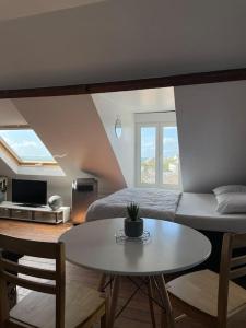 een slaapkamer met een bed en een tafel en een tafel sidx sidx sidx bij Donville vue sur la mer in Donville-les-Bains