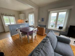 a living room with a couch and a table at Stasjonen - Sørvågen in Moskenes