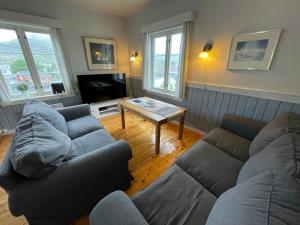 a living room with two couches and a coffee table at Stasjonen - Sørvågen in Moskenes