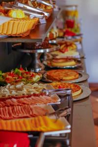 una linea a buffet con molti tipi di pizza di Pousada Constellation Lodge a Campos do Jordão
