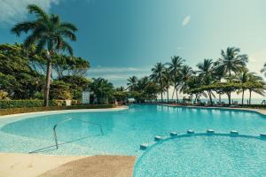 a large swimming pool with palm trees in a resort at Hermosa Palms Casa 23B -3BD - Bruno Casalvolone in Jacó