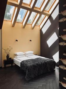 - une chambre avec un lit dans une pièce dotée de lucarnes dans l'établissement Cisowy Zakątek, à Sasino