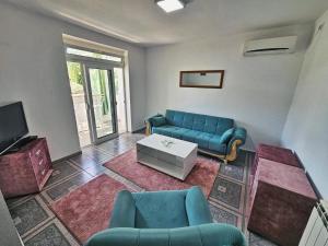 a living room with a blue couch and a table at Apartments FLORA and boat cruising in Virpazar