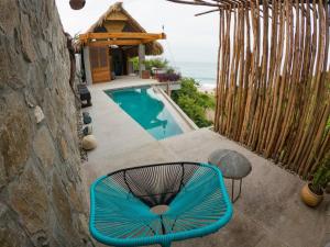 une chaise bleue assise sur une terrasse à côté de la piscine dans l'établissement Gotita, à Yolina