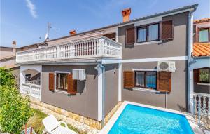 une maison avec une piscine en face de celle-ci dans l'établissement Nice Home In Liznjan With 6 Bedrooms, Wifi And Outdoor Swimming Pool, à Ližnjan
