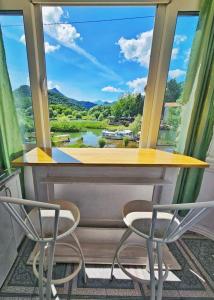 a table and two chairs in front of a window at Apartments FLORA and boat cruising in Virpazar