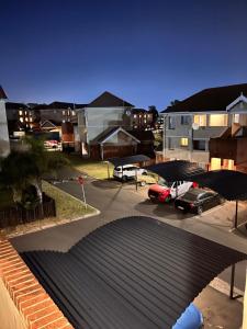 vistas a un aparcamiento con coches y edificios en One bedroom cosy apartment in Kempton Park, en Kempton Park