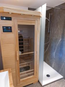 d'un meuble en bois avec une porte en verre dans la salle de bains. dans l'établissement Haus Kurparkblick Ferienwohnung Lautersee, à Mittenwald 8 autres photos