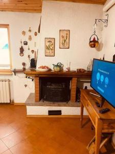 a living room with a television and a fireplace at Accogliete buen retiro a Pescocostanzo. Con garage in Pescocostanzo