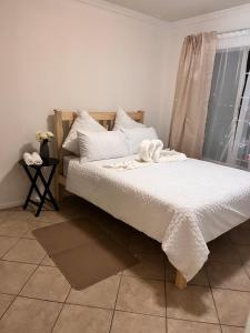 1 dormitorio con 1 cama con sábanas blancas y ventana en One bedroom cosy apartment in Kempton Park, en Kempton Park