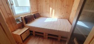 a small bedroom with a bed in a tiny house at Leśne Zacisze 2 in Łuka
