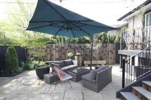 a patio with two chairs and an umbrella at The Orange Door Bungalow in Vancouver
