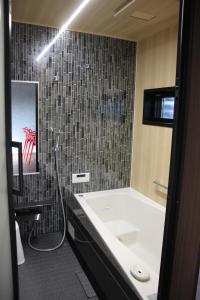 a bathroom with a tub and a sink and a shower at Marna family - Vacation STAY 69396v in Takaoka