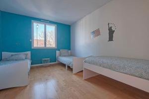a bedroom with blue walls and two beds and a window at Villa Paris Garden - 15 minutes de Disneyland Paris in Montévrain
