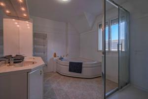 ein Badezimmer mit Badewanne, Waschbecken und Dusche in der Unterkunft Villa Paris Garden - 15 minutes de Disneyland Paris in Montévrain + 16 Fotos