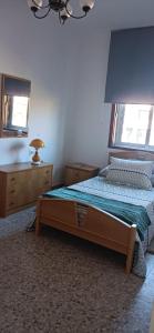 a bedroom with a bed and a dresser and two windows at A Niñada in Marín