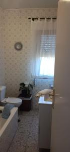 a bathroom with a sink and a toilet and a window at A Niñada in Marín