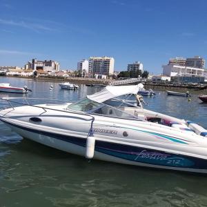 a white boat is docked in the water at GuestBoat Milagre in Faro