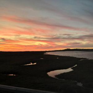 a sunset over a body of water with a sky at GuestBoat Milagre in Faro