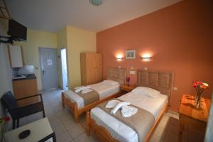 ein Hotelzimmer mit 2 Betten und einer Küche in der Unterkunft Anaxos Bay Rooms & Apartments in Anaxos