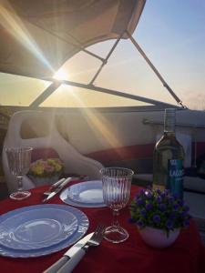 - une table avec des assiettes, des verres et une bouteille de vin dans l'établissement GuestBoat Milagre, à Faro