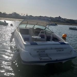 a small white boat sitting in the water at GuestBoat Milagre in Faro