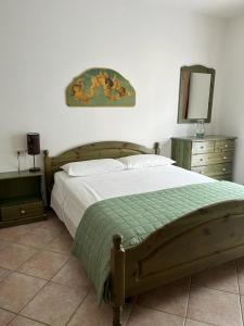 Schlafzimmer mit einem Bett, einer Kommode und einem Spiegel in der Unterkunft Appartamento Violetta in Malcesine