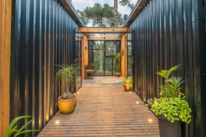 a wooden walkway with potted plants and a door at Refúgio na Serra com Banheira e Belo Nascer do Sol in Rio Rufino