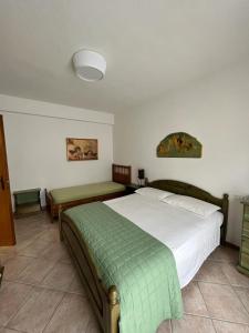 ein Schlafzimmer mit einem Bett mit einer grünen Decke darauf in der Unterkunft Appartamento Violetta in Malcesine