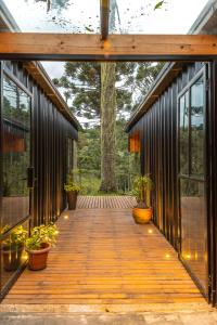 a wooden walkway with potted plants on it at Cabana na Serra Lareira e Vista Deslumbrante in Rio Rufino