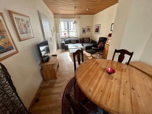 een woonkamer met een houten tafel en een bank bij Ferienhaus Flensburg Sandberg in Flensburg