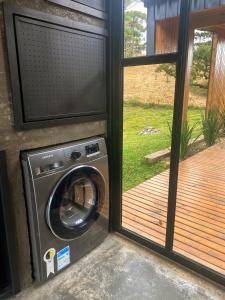 a washing machine sitting next to a sliding glass door at Cabana na Serra Lareira e Vista Deslumbrante in Rio Rufino +61 photos