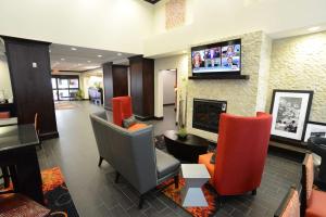 a lobby with chairs and a fireplace and a tv at Hampton Inn & Suites Albany at Albany Mall in Albany