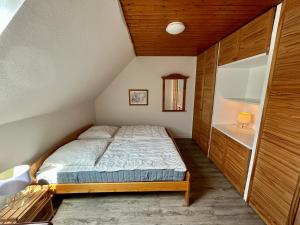 een kleine slaapkamer met een bed op zolder bij Ferienhaus Flensburg Sandberg in Flensburg