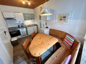 een kleine keuken met een houten tafel en stoelen bij Ferienhaus Flensburg Sandberg in Flensburg