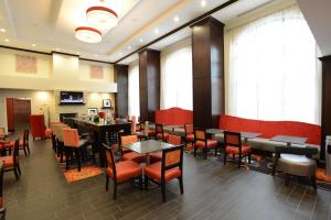 uma sala de jantar com mesas, cadeiras e janelas em Hampton Inn & Suites Albany at Albany Mall em Albany