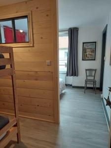 a room with a wooden wall and a room with a bedroom at L'escale du centre du lac de Gérardmer in Gérardmer
