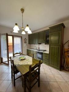 eine Küche mit einem Holztisch sowie einem Tisch und Stühlen in der Unterkunft Appartamento Violetta in Malcesine
