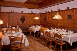 a dining room with tables and chairs and chandeliers at Sonnenresidenz Friedheim in Weerberg