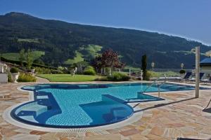 a swimming pool with a mountain in the background at Sonnenresidenz Friedheim in Weerberg